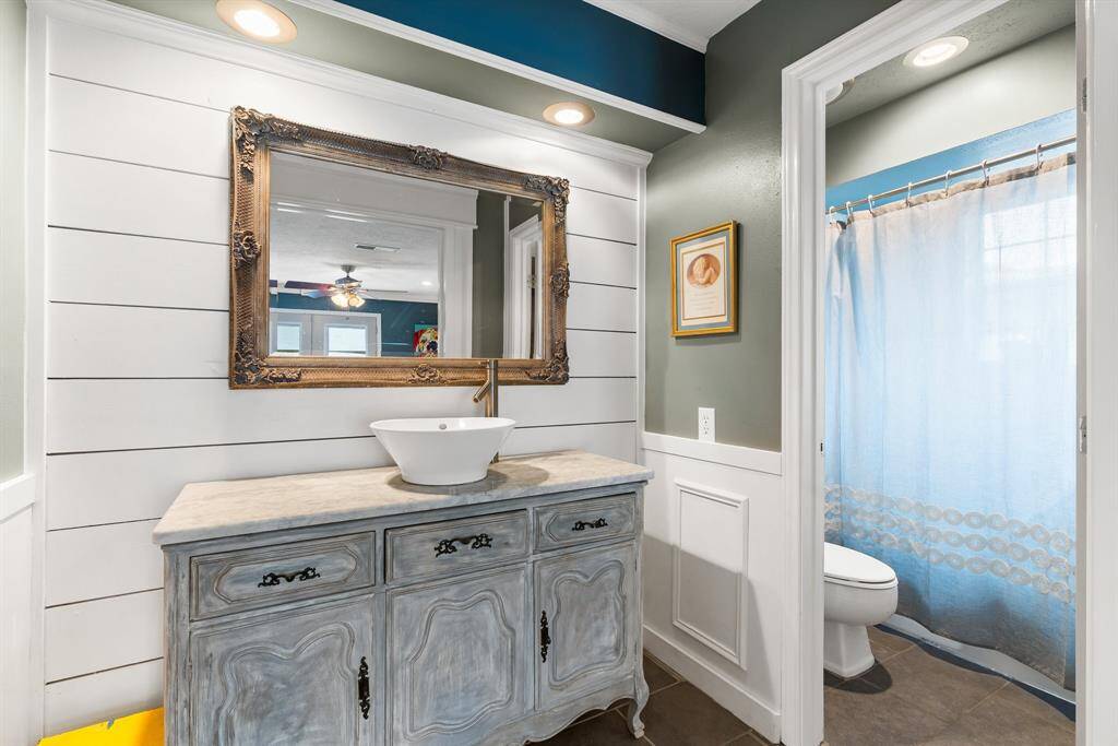 Elegant upstairs bathroom featuring a stylish vanity, framed mirror, and modern fixtures, offering both functionality and charm.