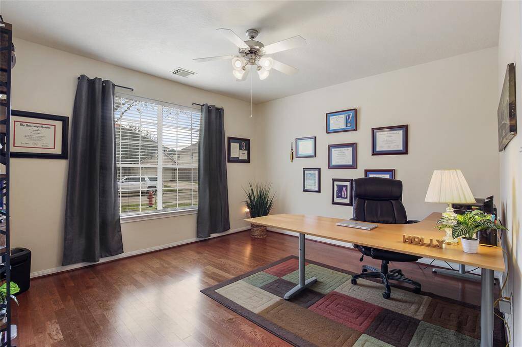 Home office large enough for multiple desks and furniture arrangements.