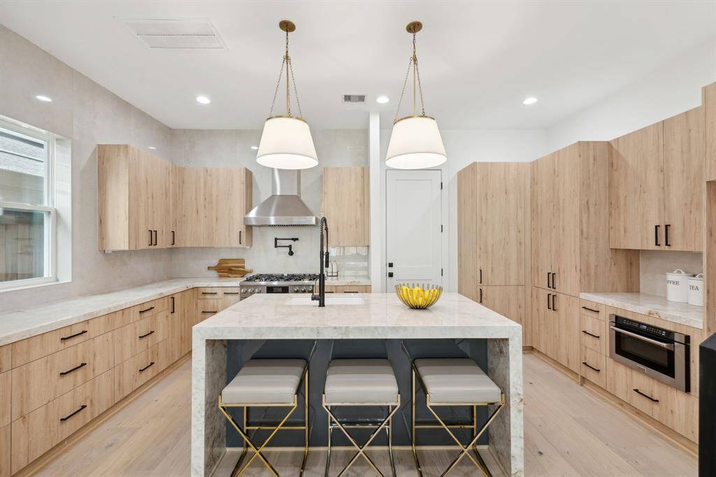 The open design of this first floor perfect for entertaining and everyday life. The kitchen features white oak cabinetry, waterfall countertops and ceiling height backsplash. Island seating is perfect for quick meals or morning coffee.