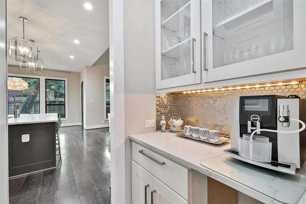 Butler's pantry features glass cabinetry, quartz countertop and is across from walk in pantry.