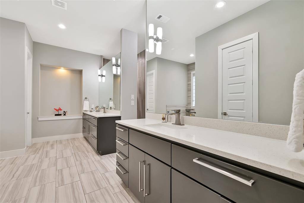 Luxurious and spa like primary bathroom with dual vanities, soaking tub and tiled shower.