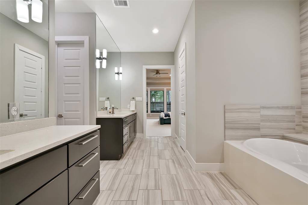 View of primary bathroom.  Timeless quartz countertops and tile flooring.  Access to two large his/her closets with abundant space and built ins-perfect for staying organized!