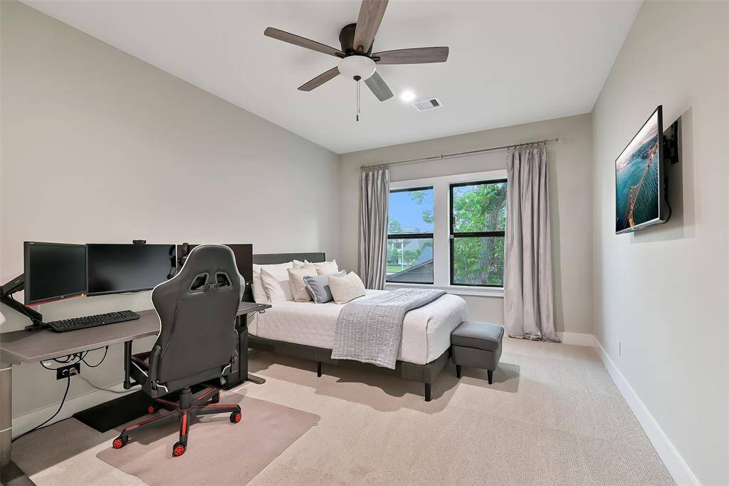 Secondary bedroom with views, window treatments, and recessed lighting.