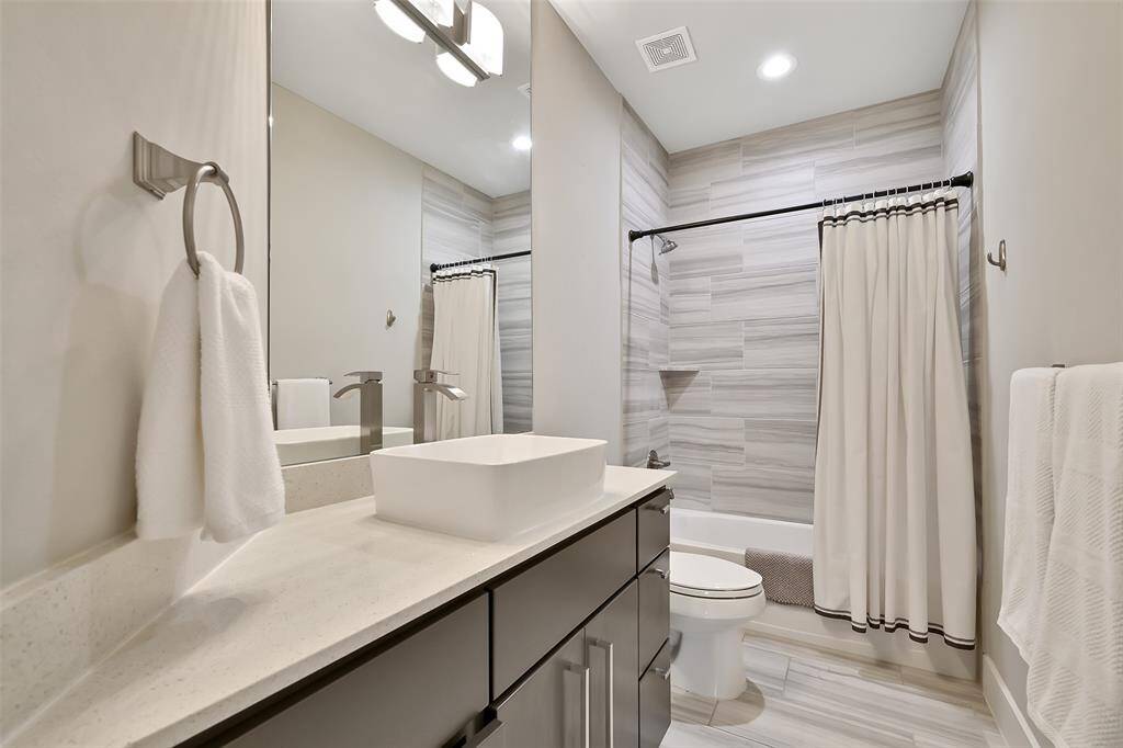 Secondary bathroom with vessel sink and quartz countertop.