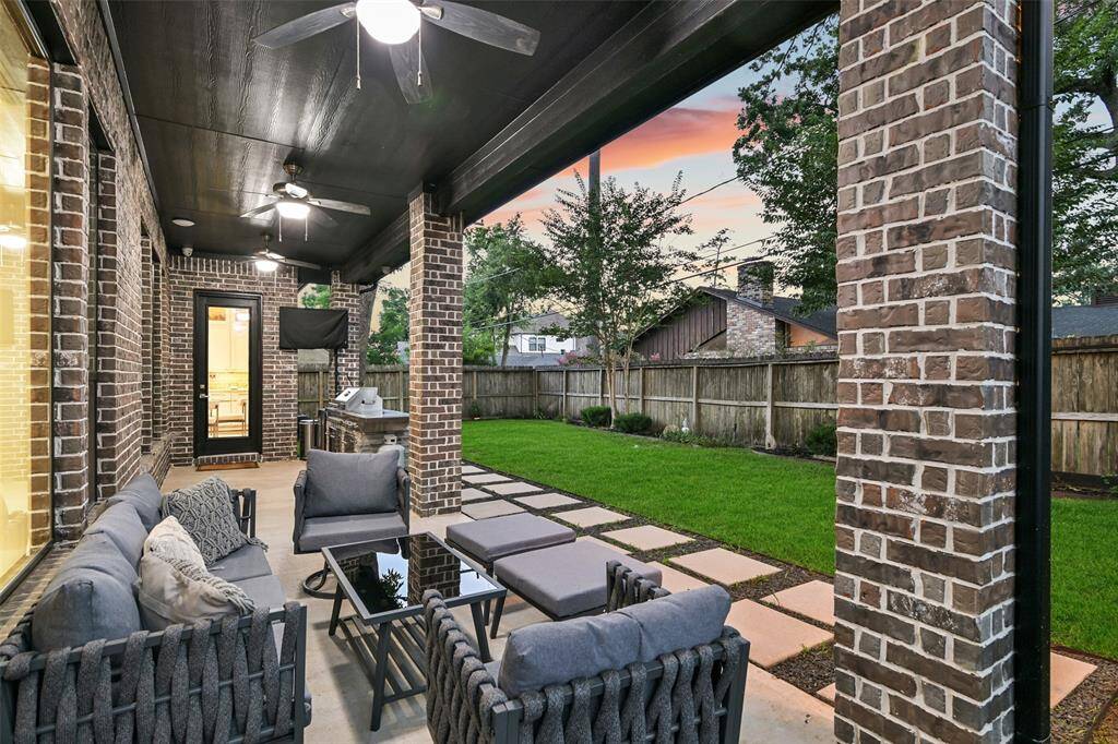 Enjoy relaxing on the covered patio with outdoor kitchen and manicured lawn.