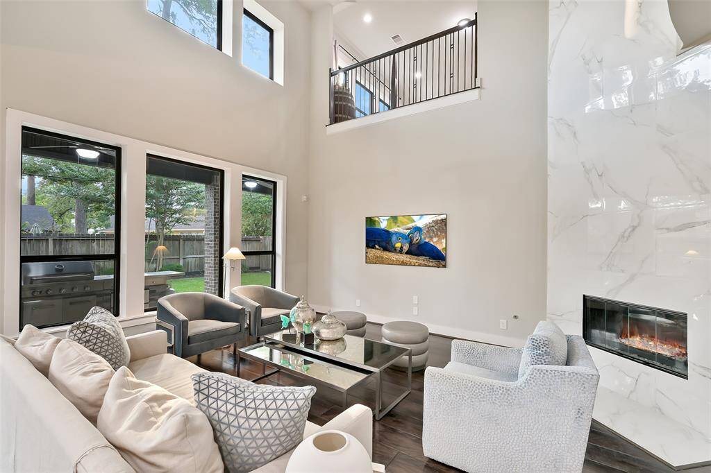 Another view of the living room shows large windows that overlook backyard.  The windows provide lots of natural light throughout the living areas.