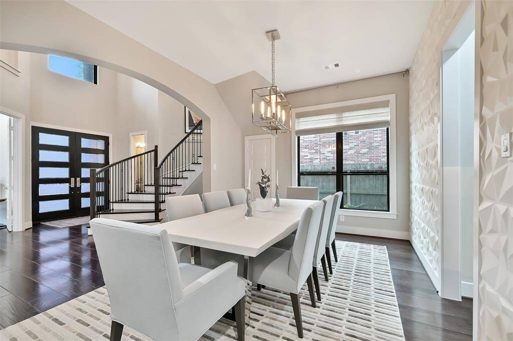 Formal dining room is open to foyer and butler's pantry. Features three-dimensional wall accent, classic chandelier, and is sophisticated vibe-excellent flow for entertaining.