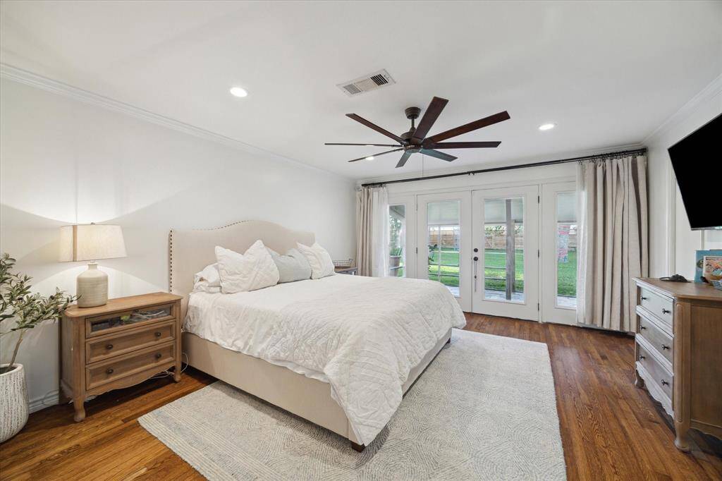 Oversized primary bedroom with gleaming hardwood floors, two large closets and french doors leading to the stunning backyard.