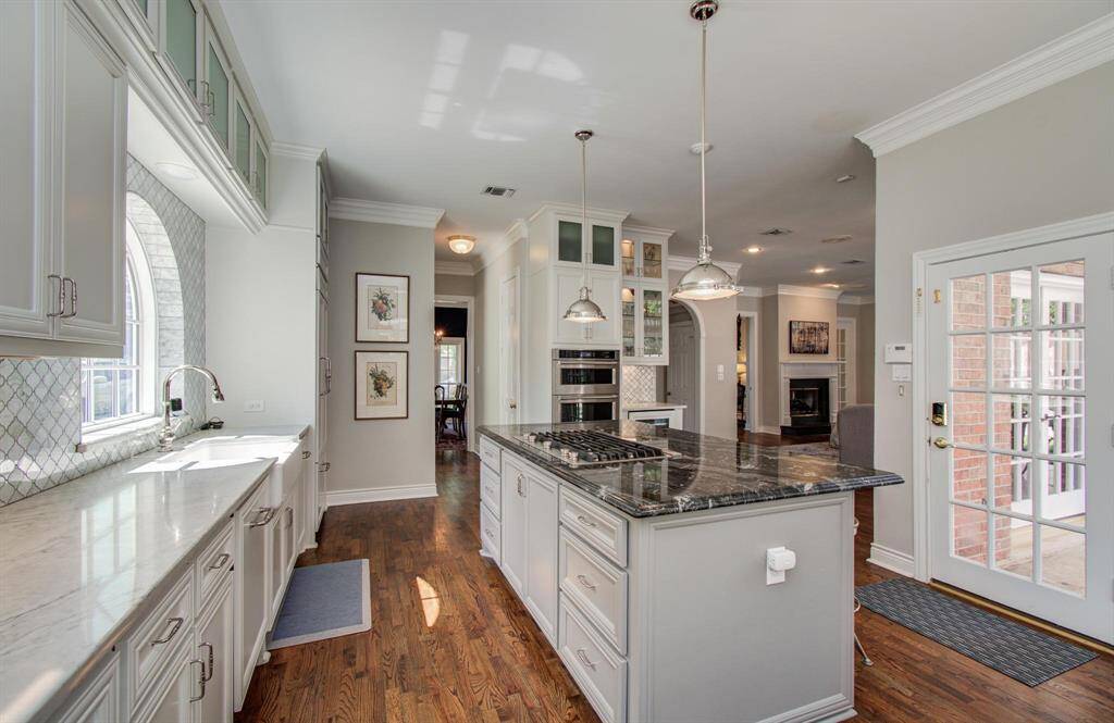 Polished nickel faucet and a farmhouse sink. Note the open view of the kitchen to den