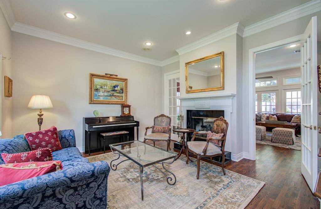 Formal living room could also be used as a home office if desired. French doors flank a double sided fireplace and open to the family room