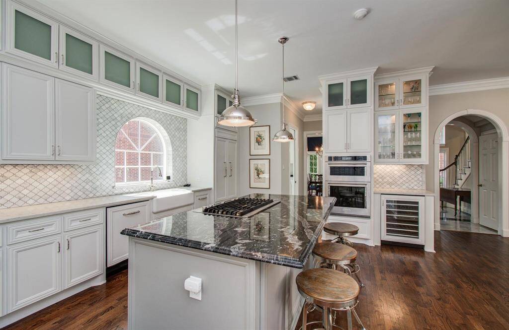 Double ovens for the ultimate chef!  A wine refrigerator as well as glass front storage for barware and under cabinet lighting highlight the bar area