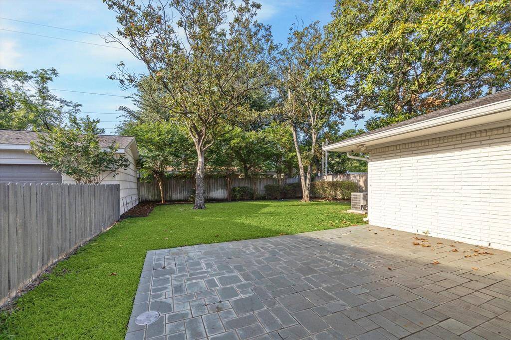 Oversized backyard with patio. The detached garage and driveway are to the left.