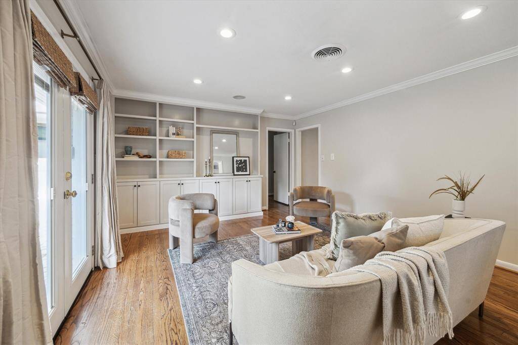 Spacious living room with custom built-ins and window treatments.