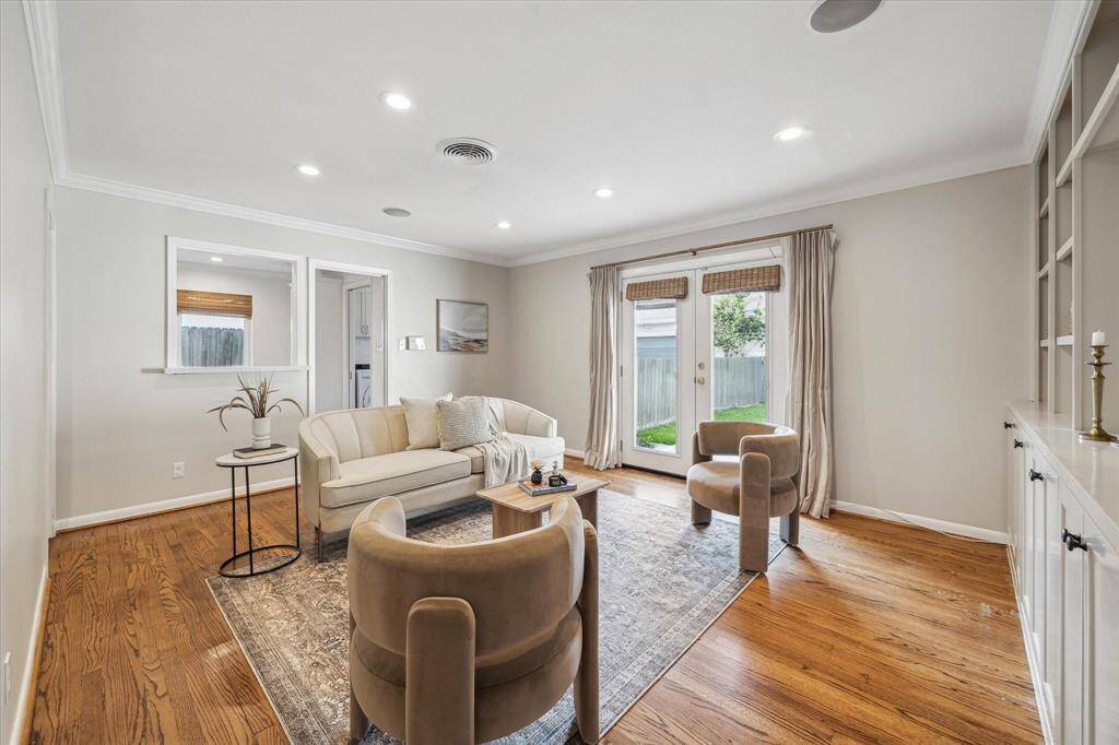 Spacious living room with double doors leading to the back patio.