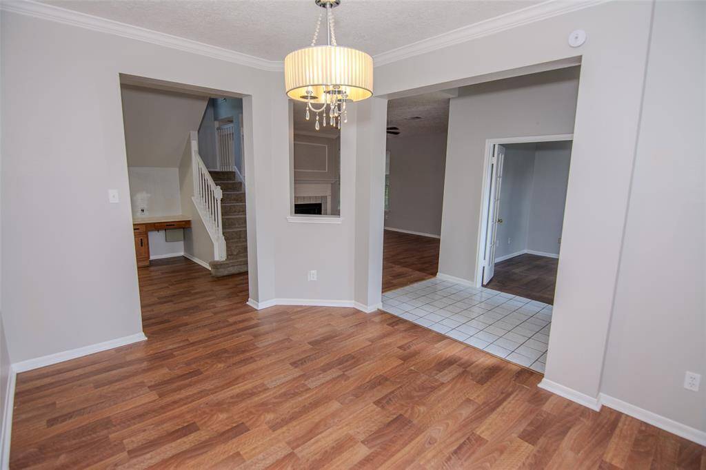 Foyer into the Dining Room with Staircase Exposure under a Quaint Chandelier.