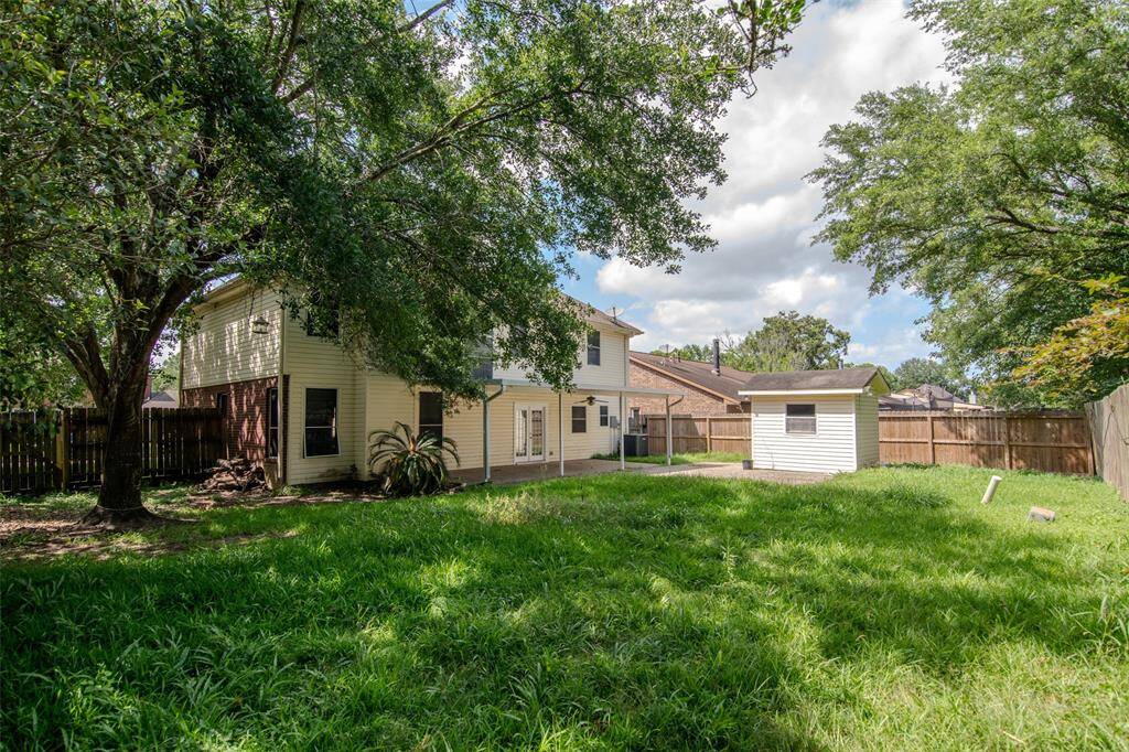 Spacious Back Yard with Storage Shed and Covered Back Patio.