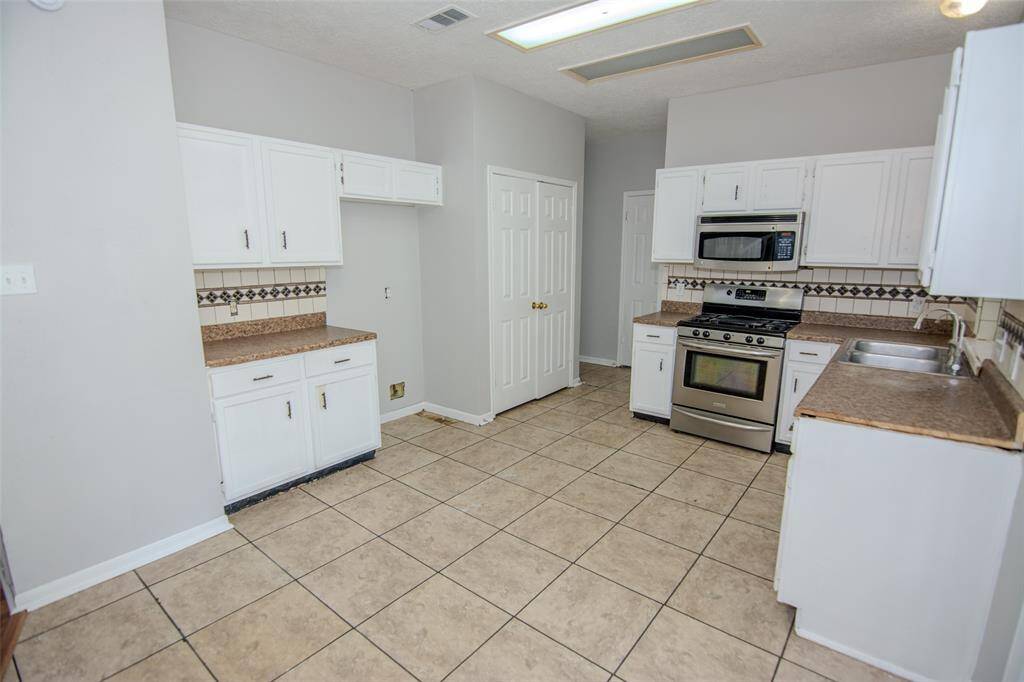 High Ceilings in the Kitchen with Stainless Steel Appliances and a pantry.