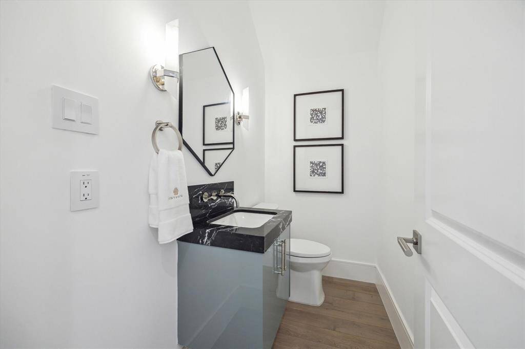 First floor powder features striking Nero Marquina Marble countertop, Kallista luxury fixtures and under-mount sink, and additional storage.