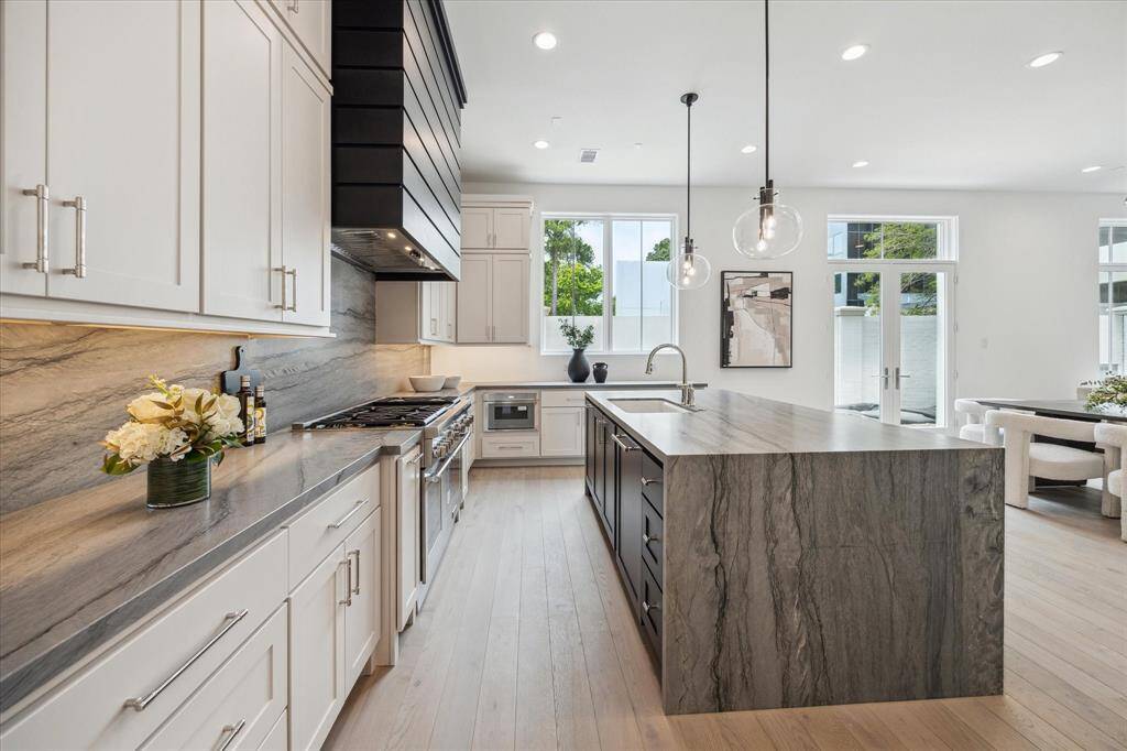 The kitchen showcases a premium Thermador appliance package, which includes a 48” Pro Harmony gas range, a 24” built-in MicroDrawer microwave, a 24” custom panel dishwasher, a 30” custom panel fresh food refrigerator, and 30” freezer columns.
