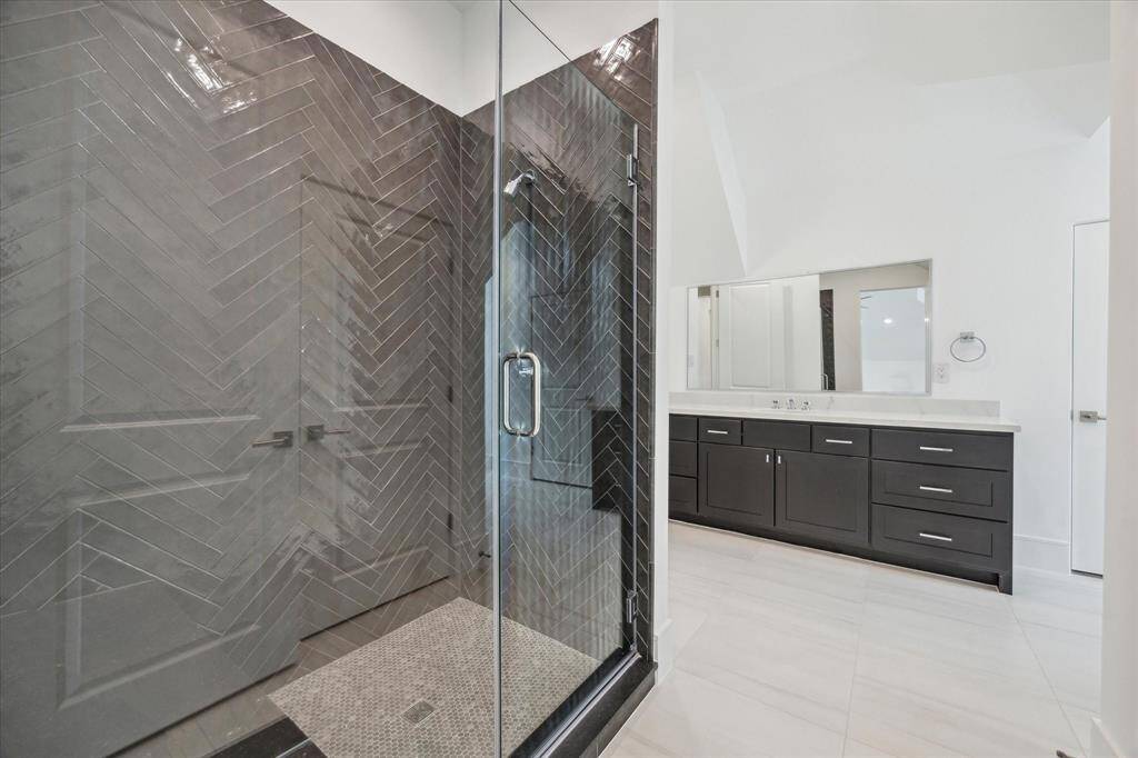 Hollywood bath on the third floor with large counter space, glass-encased shower, and walk-in closet.