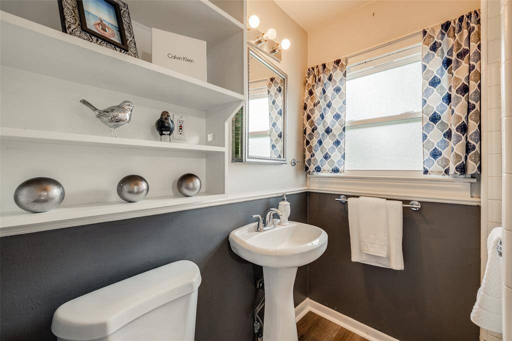 Primary Bathroom with shower, pedestal sink, shelves for extra storage