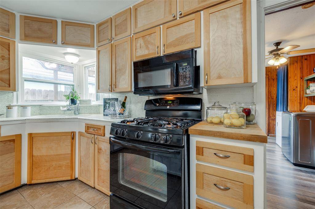 kitchen with wooden cabinets, gas cooker, microwave