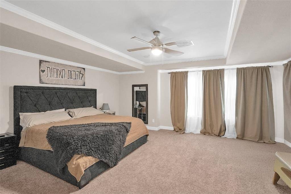 The large primary suite with tray ceiling and natural light.