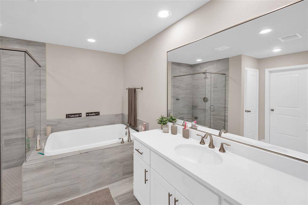 The luxurious primary suite bathroom with separate tub and standing shower.