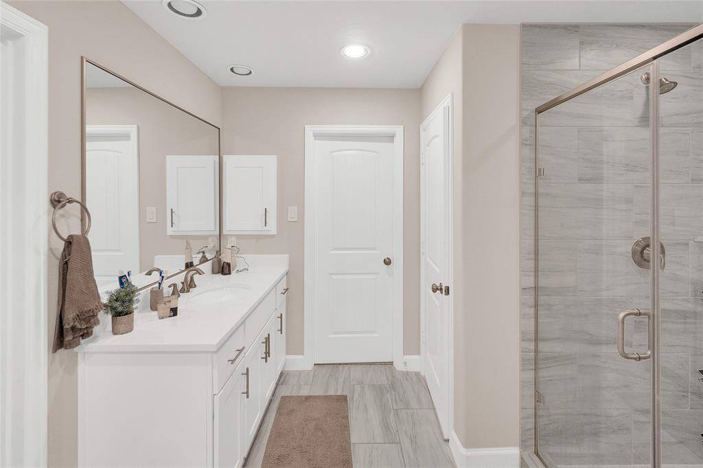 Primary suite bathroom, doors lead to a large walk in closet.