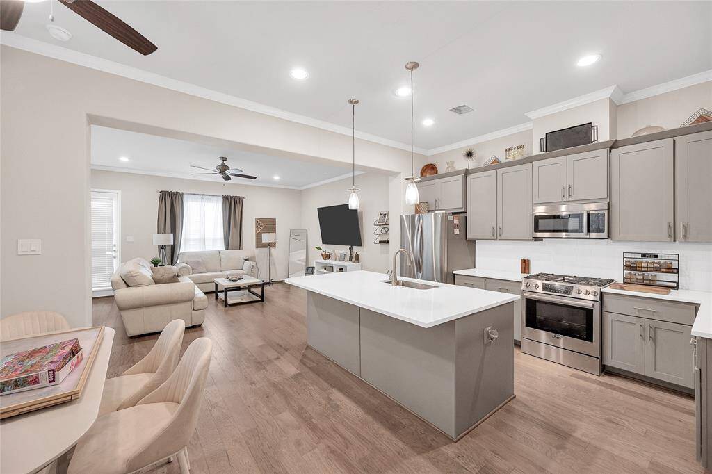 Chef's kitchen with plenty of storage, gas range cooktop, and island with bar seating. The breakfast room is situated to the left of the kitchen.