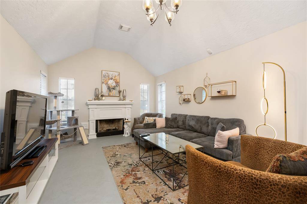 The living room features a wood-burning fireplace, soaring ceilings, and generous space for relaxing or gathering—ready to shape into the heart of the home.