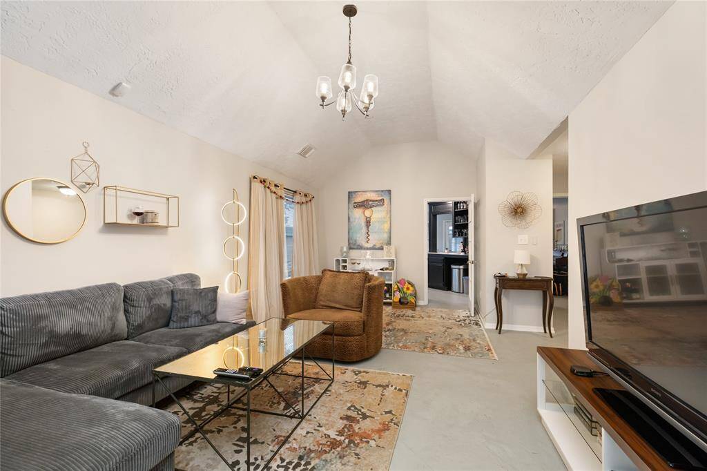 Just off the entry, the living room flows seamlessly into the kitchen—imagine hosting friends here, with conversation moving easily from the sofa to the breakfast bar, or enjoying a cozy night in with everything within reach.