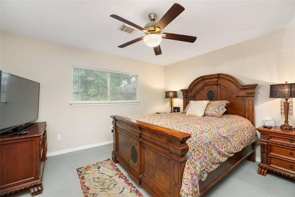 The primary bedroom offers ample space, a ceiling fan for comfort, and natural light that filters through the window—creating a calm retreat.