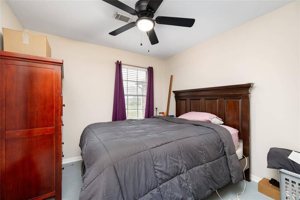 A secondary bedroom with ceiling fan and natural light offers a simple, adaptable space for guests, home office use, or daily living.