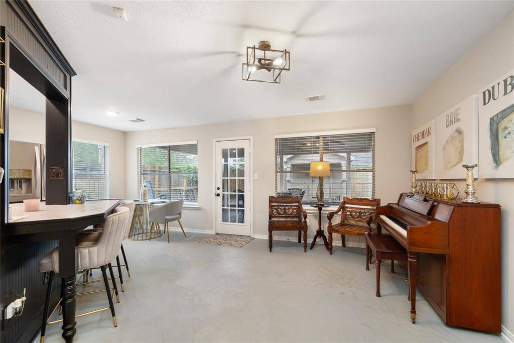 The breakfast bar adds character with wainscoting details and spindle-style legs, while the adjacent area offers flexibility—perfect for a formal dining space, music room, or creative corner.