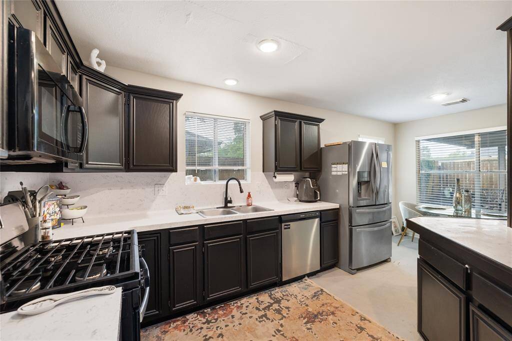 The kitchen is filled with natural light, thanks to a window above the sink and a large side window that offers a clear view of the spacious patio. Picture yourself prepping meals while keeping an eye on the backyard—or stepping out to grill and dine outdoors with ease.