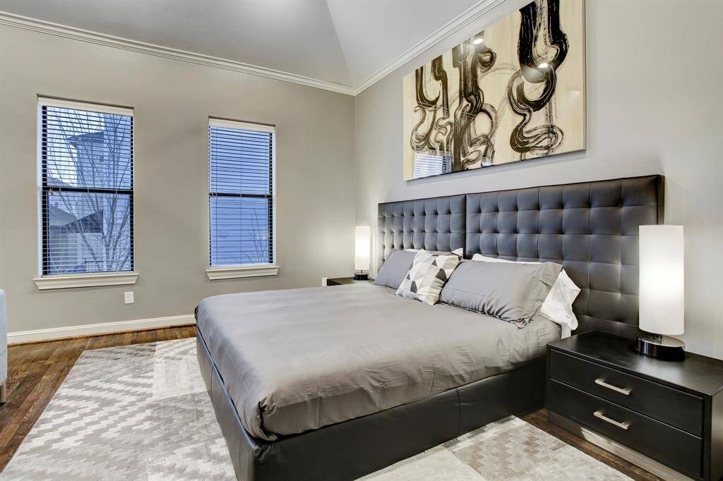 Elegant Primary Bedroom with cathedral ceiling, ensuite bath and walk-in closet.  Notice the king-sized bed & night stands, and sophisticated neutral palette of furnishings.