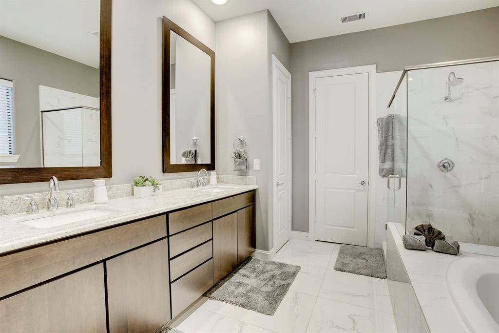 The Primary Ensuite Bath has a wide vanity with double sinks & a granite countertop, tile flooring, a deep soaking tub, a separate walk-in shower with tile surround, linen closet and 2 walk-in closets.