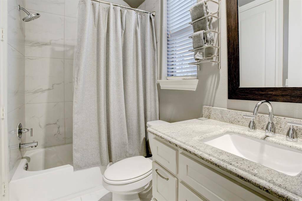 Shared Bathroom between 2 Guest Bedrooms.  Notice the granite countertop on the vanity and the tub/shower clad in tile, plus the window for natural light.