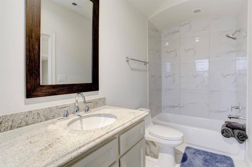 The lovely 3rd Floor Bathroom has a shower/tub clad in tile with a barrel ceiling, and a wide vanity with a stunning granite countertop.