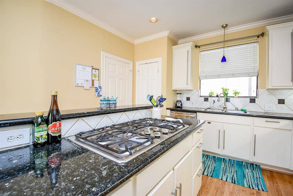 Gas cooktop and modern black countertops.