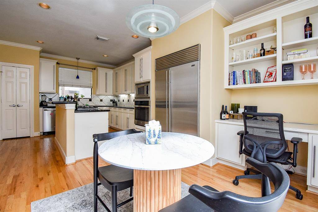Pendant lighting highlights the white cabinets and wood floors.