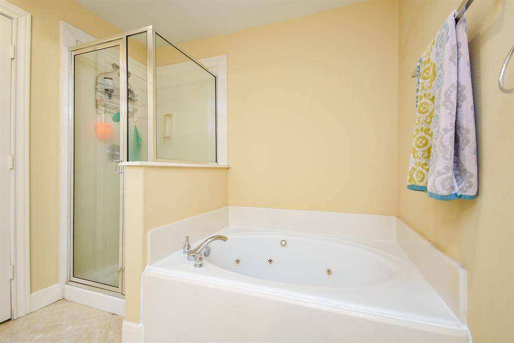 Soaking tub sits adjacent to stand up shower.