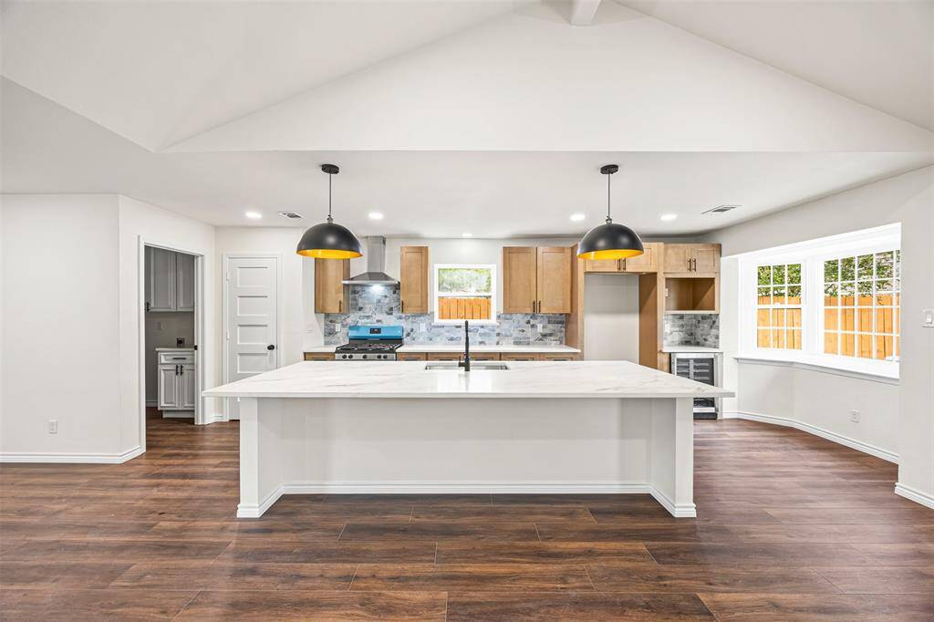 This stunning, fully renovated kitchen boasts sleek quartz countertops that offer both durability and elegance. A high-performance gas range provides precision cooking, while the spacious island seamlessly connects to the open living area—perfect for entertaining or everyday convenience.