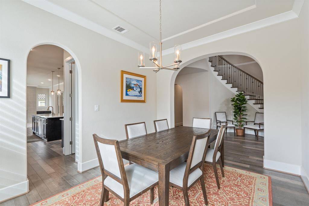 Dedicated dining room with access from the kitchen. A upgraded lighting, arched entry ways, and abundant natural light create a warm, inviting atmosphere for hosting family and guests.