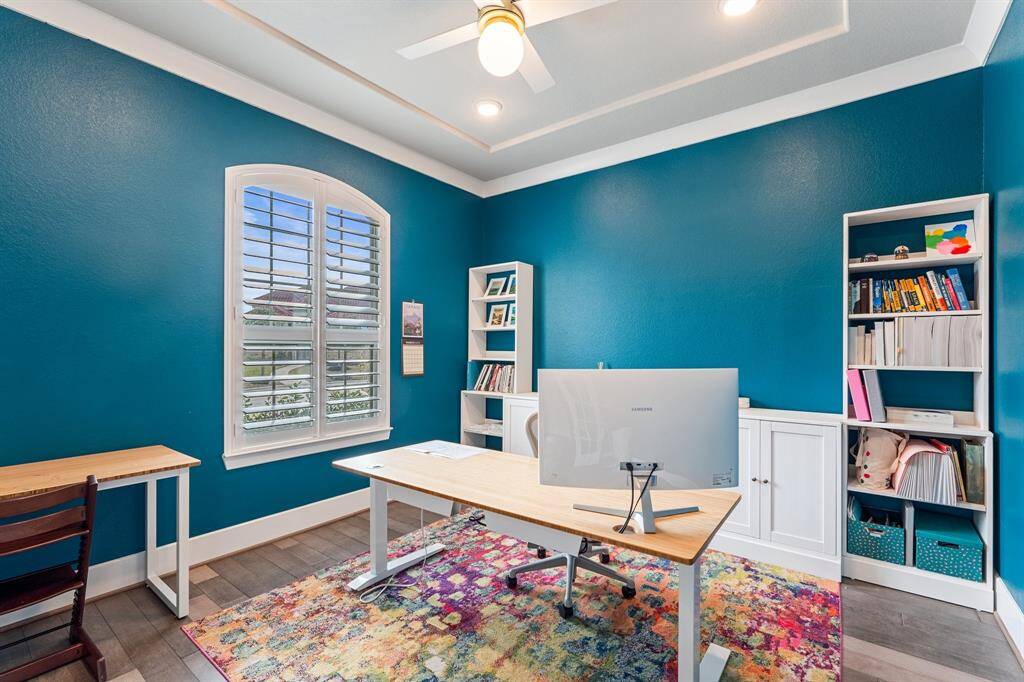 Elegant home office with double doors, arched window, and built-in shelving — creating the perfect environment for productivity or quiet reflection.