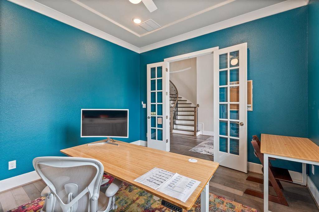 Another perspective of the home office, highlighting the peaceful atmosphere with abundant natural light from the arched window. Double doors provide privacy, and built-in storage adds both function and style.