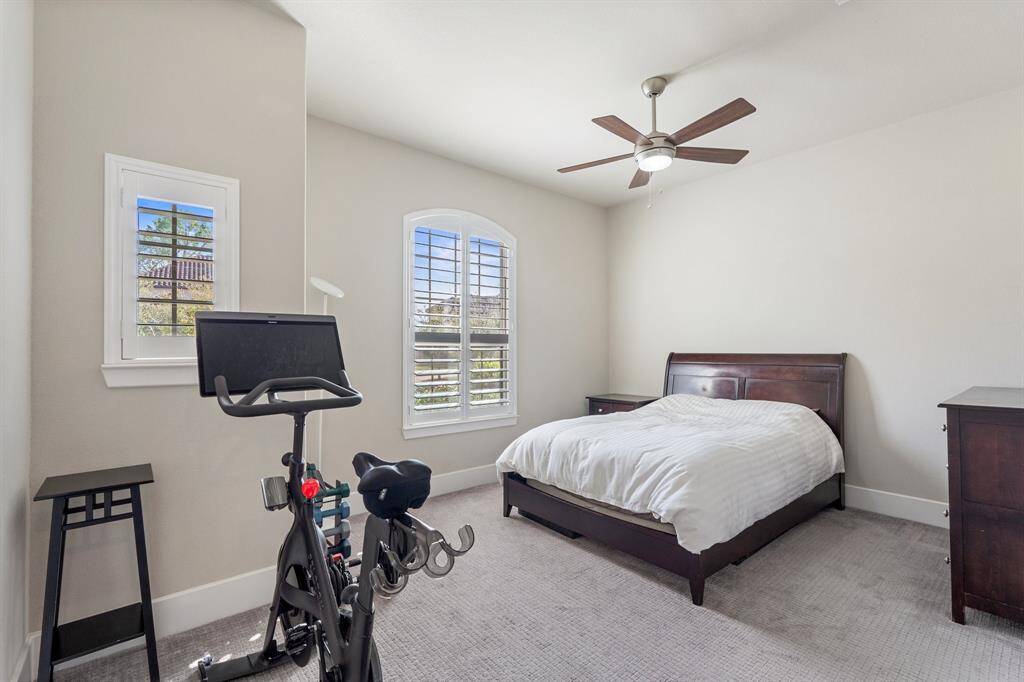 Main floor guest suite, ideal for multi-generational living. Featuring a ceiling fan for added comfort, plush carpet, and neutral finishes, this suite creates a welcoming and serene atmosphere.