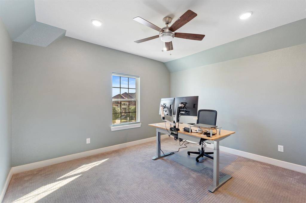 Serene secondary bedroom with plush carpeting, an oversized window, and a ceiling fan for added comfort. Conveniently located near a private bathroom for privacy and convenience.