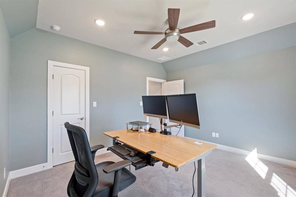 Another view of the Serene secondary bedroom with plush carpeting, an oversized window, and a ceiling fan for added comfort. Conveniently located near a private bathroom for privacy and convenience.